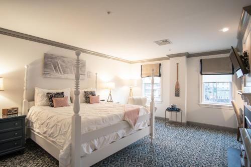 米斯蒂克捕鲸船酒店的卧室配有白色的床和2扇窗户。