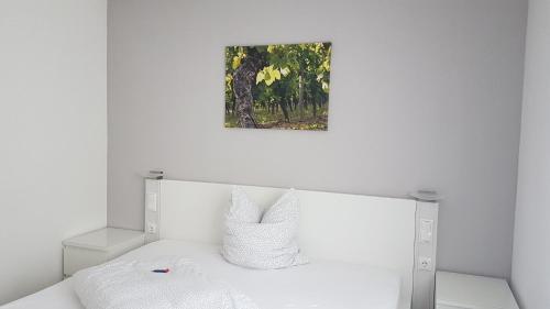 RamsthalGästezimmer Fuchs的卧室配有一张白色床,墙上挂着一幅画