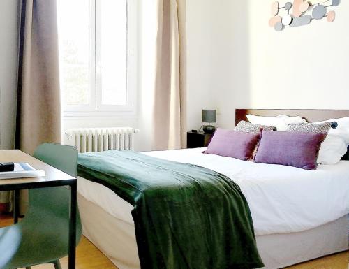 Beaufort-sur-GervanneHOTEL DU MIDI的一间卧室配有一张铺有紫色和绿色床单的床