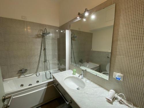卡利亚里NEW Bcomfort的一间带水槽、浴缸和镜子的浴室