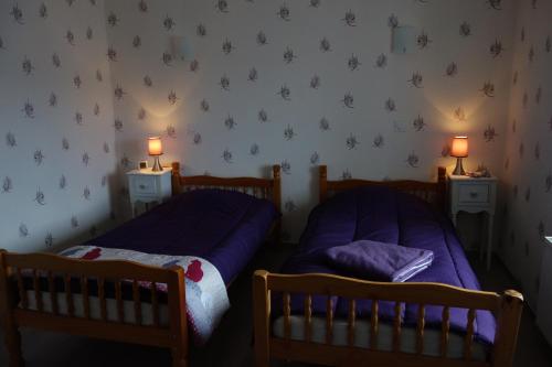 Le ClerjusLe Champ的卧室内的两张床,墙上有两盏灯