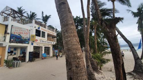 长滩岛戴夫咕噜长滩岛海滩度假酒店的海滩旁的棕榈树,有建筑