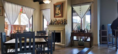 圣克里斯托瓦尔-德拉斯卡萨斯Hotel Ocho Barrios的一间带壁炉和桌椅的用餐室