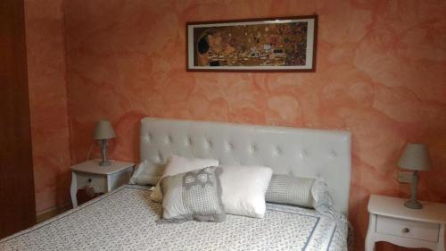 卡斯泰洛泰西诺Alloggio Castello Tesino的卧室配有一张白色床、两张桌子和两盏灯。