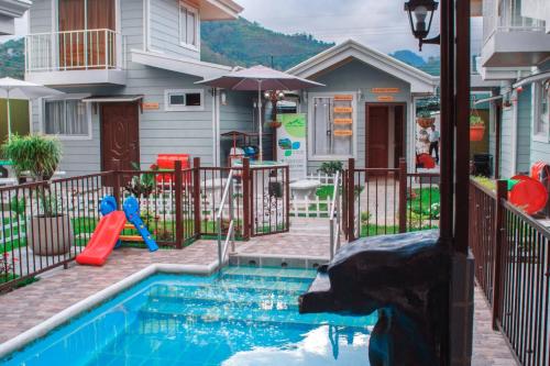 奥罗西Villas Orosi Valley的一座带水滑梯的房屋前的游泳池