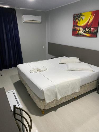 福塔莱萨阿奎瑞斯酒店的一间卧室配有一张带白色床单的大床