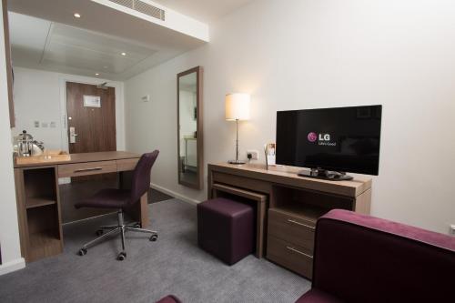 伯明翰伯明翰斯泰布里奇套房酒店的酒店客房配有书桌、电视和书桌