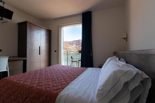 克鲁斯安湖拉戈罗莎蒙德旅馆的一间卧室设有一张床和一个美景窗户。