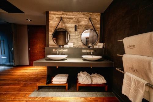 法弗舍姆Cave Hotel near Canterbury的浴室设有2个水槽和2面镜子