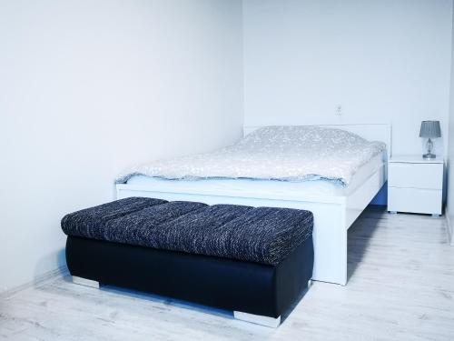 阿尼克什奇艾Black & White Studio的一张白色的床,里面装有黑色的软垫