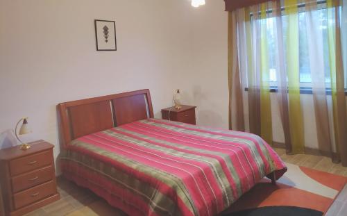 普拉亚达维多利亚Moradia da Graça的一间卧室配有一张床、一个梳妆台和一扇窗户。