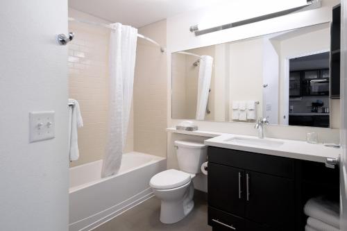 格里利格里利烛木套房酒店的白色的浴室设有卫生间、浴缸和水槽。