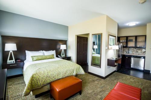 弗赖拉辛Staybridge Suites Plano - Legacy West Area, an IHG Hotel的酒店客房带一张床和一个厨房