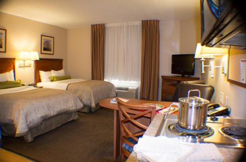 杰克逊维尔Candlewood Suites Jacksonville, an IHG Hotel的酒店客房设有两张床和一张桌子。