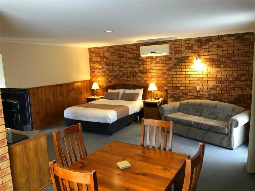 巴拉腊特维多利亚时代汽车旅馆的酒店客房配有床、沙发和桌子。