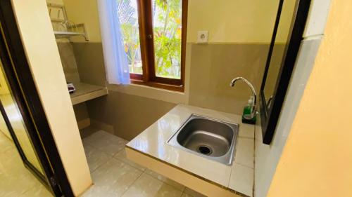 乌鲁瓦图攀达瓦海滩民宿酒店的一间带水槽和窗户的小浴室