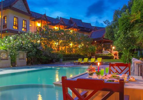 慕斯普万纳利度假酒店的餐桌,位于带游泳池的房子前