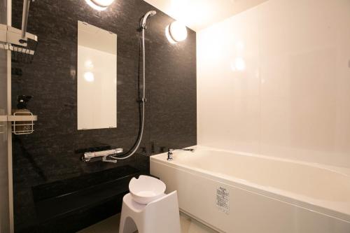 松本The Celecton Matsumoto的带浴缸、卫生间和盥洗盆的浴室