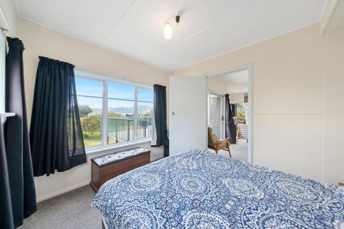 帕拉帕拉乌姆海滩The Green Trout - Paraparaumu Beach Holiday Home的一间卧室设有一张床和一个窗口