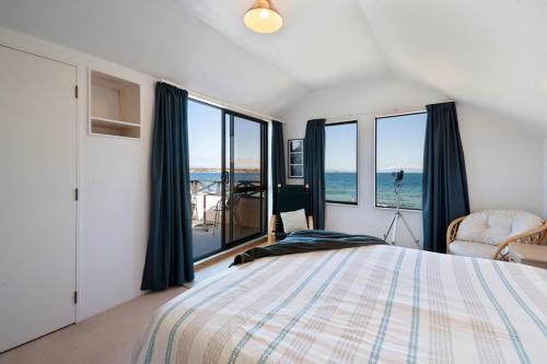 陶波Fenworth - Taupo Holiday Home的一间卧室设有一张大床,享有海景
