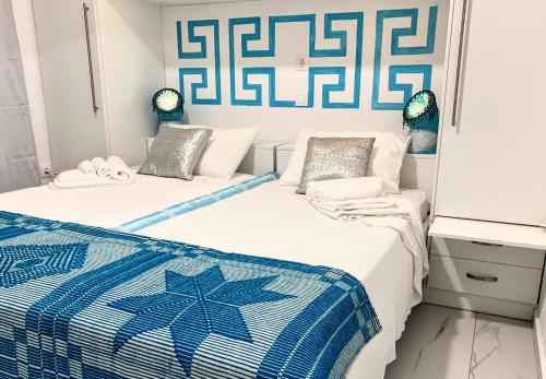 PeramaSuite of light rooms的蓝色和白色的客房内的两张床