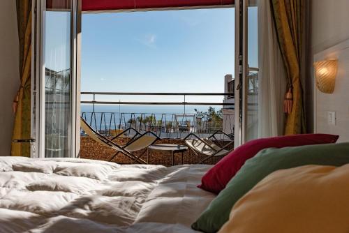圣雷莫王子酒店的一间卧室设有一张床和一个大窗户