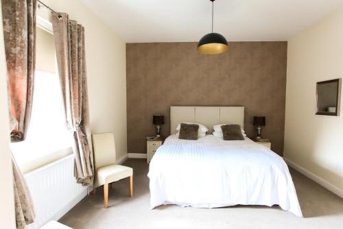 劳斯The Kings Head的卧室配有白色的床和窗户。
