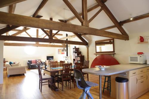 GlasburyGlanhenwye Courtyard Cottages的厨房和带木梁的客厅