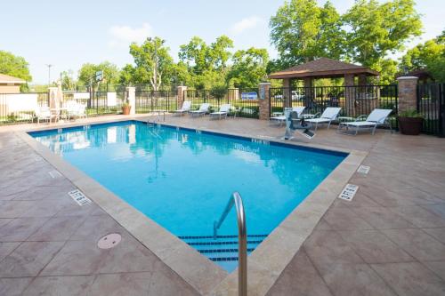 莱克杰克逊Staybridge Suites - Lake Jackson, an IHG Hotel的一个带椅子的游泳池和一个凉亭