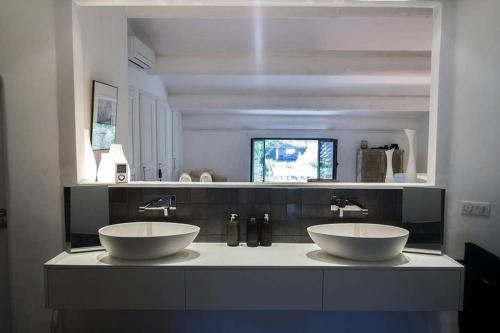 沙托雷纳尔MAS SAINT GEORGES DE L'ORATOIRE的一间带两个盥洗盆和大镜子的浴室
