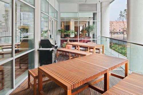 利物浦利物浦住桥套房酒店的大楼内的阳台配有长凳和桌子