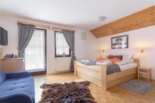 博希尼Apartments Ukanc的一间卧室配有一张床和一张蓝色的沙发