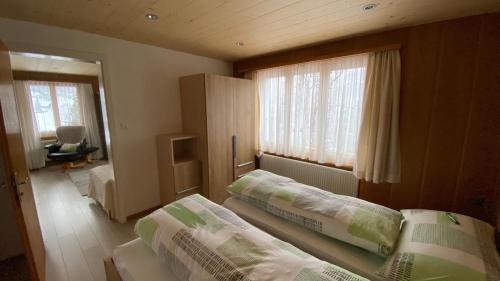 翁根艾彻里格小屋酒店的一间卧室设有两张床和窗户。