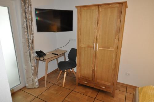 MichelfeldD´r Rechenmacher的客房设有木制橱柜、椅子和桌子。