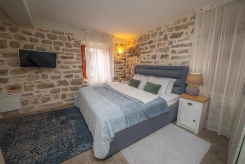科托尔安提卡民宿的一间卧室配有一张石墙床