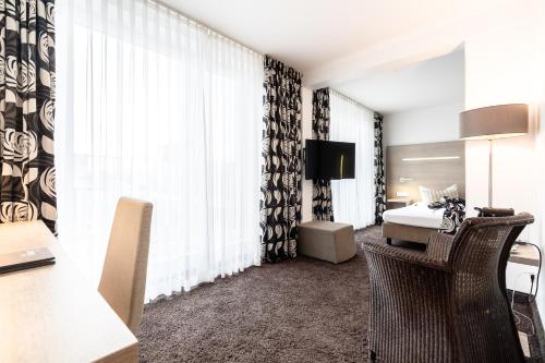 慕尼黑迪马斯市酒店的酒店客房配有一张床和一张带椅子的书桌