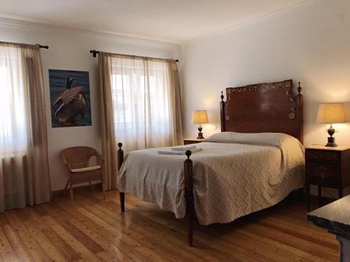 费雷拉杜阿连特茹Monte da Floresta B&B的一间卧室设有一张大床和两个窗户。