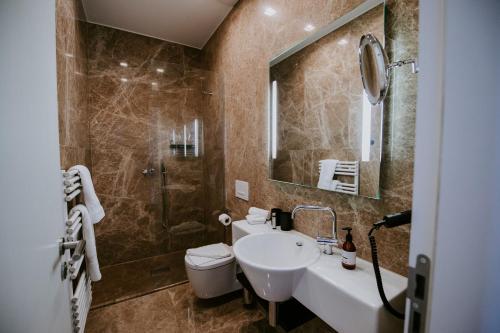 门兴格拉德巴赫圣乔治宫酒店的一间带水槽、卫生间和镜子的浴室