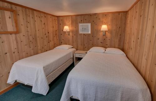 巴克斯顿Outer Banks Motel的木墙客房的两张床