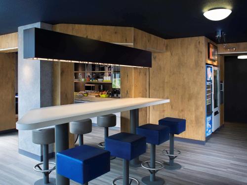 沙勒莱索尚贝里萨德查尔莱斯莱斯埃奥克斯宜必思酒店的厨房配有带蓝色吧台凳的吧台