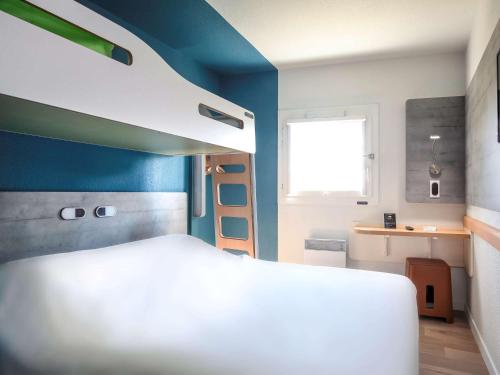 阿布维尔Hotel Ibis Budget Abbeville的卧室配有白色的床和蓝色的墙壁
