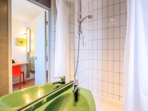 里摩日里摩日宜必思快捷酒店的带淋浴的浴室,配有绿色浴缸