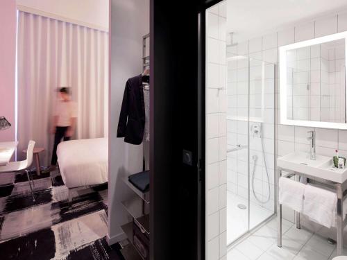 波尔多Mama Shelter Bordeaux Centre的带淋浴和盥洗盆的浴室以及1张床。