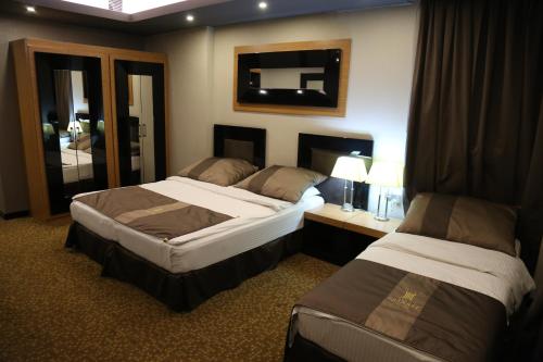 埃尔比勒埃尔比勒石英酒店 的酒店客房,设有两张床和镜子