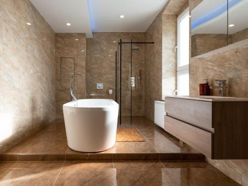 开姆尼茨Moderne City Appartments im Stadtzentrum的浴室配有白色浴缸和淋浴。