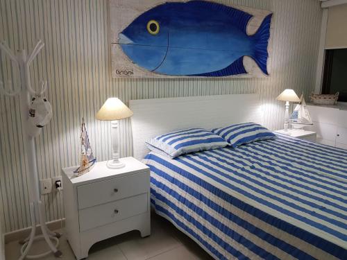 塔曼达雷Carneiros Beach Resort Tamandaré Flat的卧室的墙上挂着一幅蓝色的鱼画