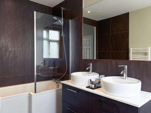 Chinnor泰姆蓝波特美居酒店的一间带两个盥洗盆和大镜子的浴室