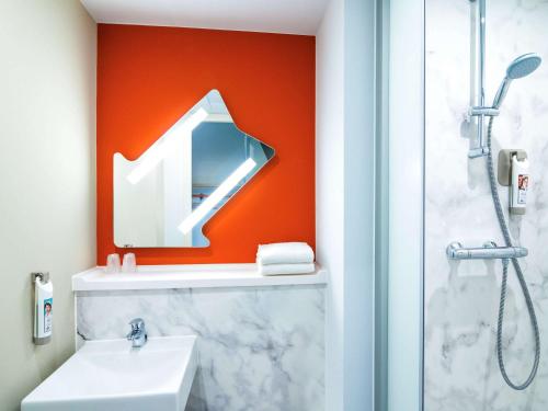 鹿特丹宜必思经济型酒店鹿特丹海牙机场店的一间带水槽、镜子和淋浴的浴室