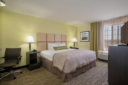 Del City坎德尔伍德德尔城套房酒店的酒店客房配有一张床、一张桌子和一把椅子。