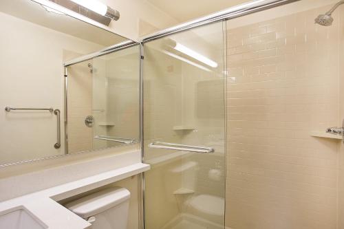 奥克格罗夫Candlewood Suites Fort Campbell - Oak Grove, an IHG Hotel的一间带玻璃淋浴和卫生间的浴室